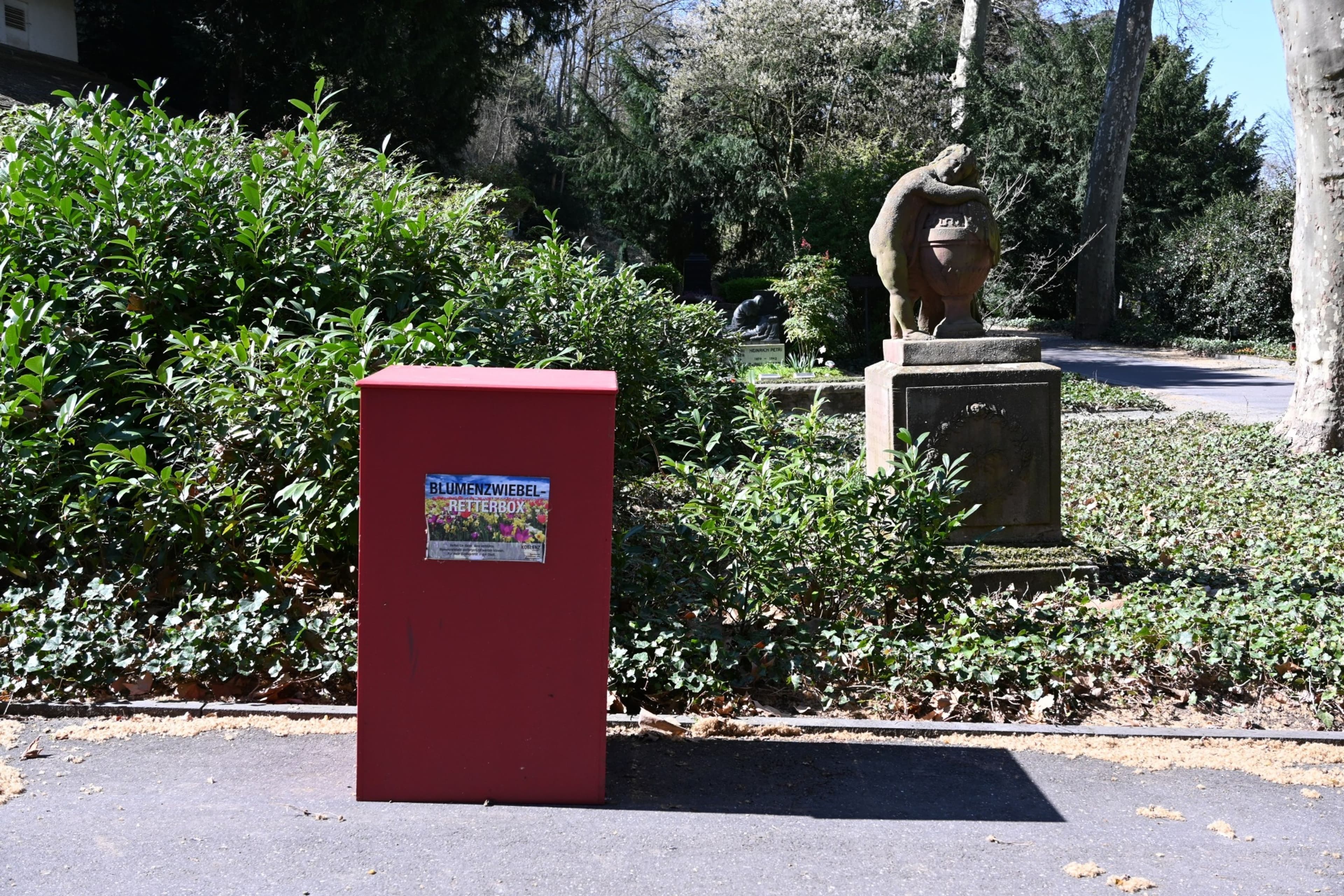 Rote Retterboxen für Blumenzwiebeln auf Friedhöfen